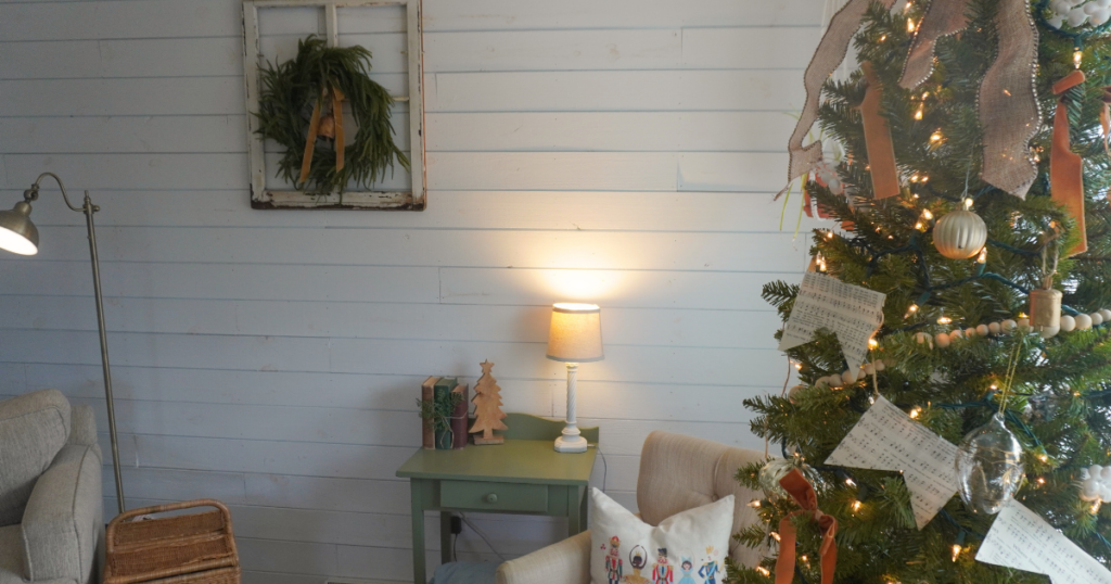 Close up of tree with wreath on wall and vintage books and wooden decorative tree