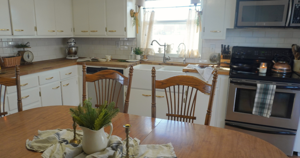 Part of table with view of counter with cookies and cookbook on counter. Sconces decorated with greens and ribbon.