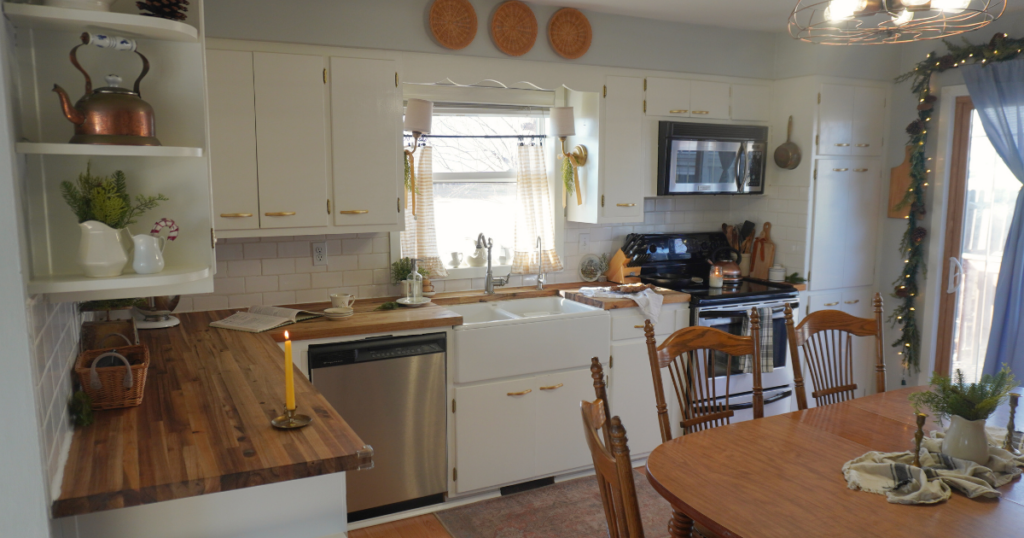Kitchen view with counters and cabinets and table. Candles and greenery and cookies for Christmas