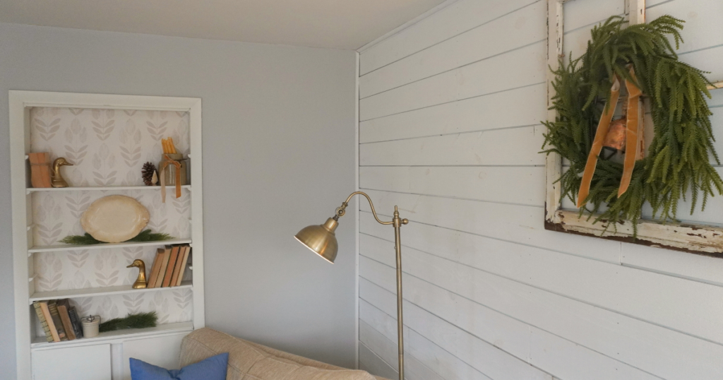 Wreath on decorative window and built-ins with candles and greenery.