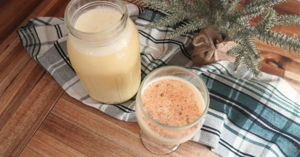 Eggnog in quart mason jar with glass sprinkled with nutmeg