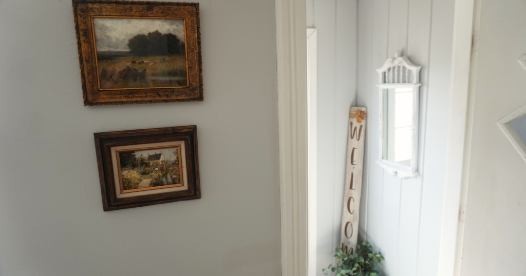 Artwork with Spring cottage and pasture land on wall.