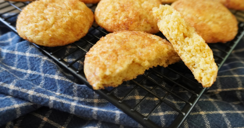broken cookie on front of cooling rack with other cookies behind.