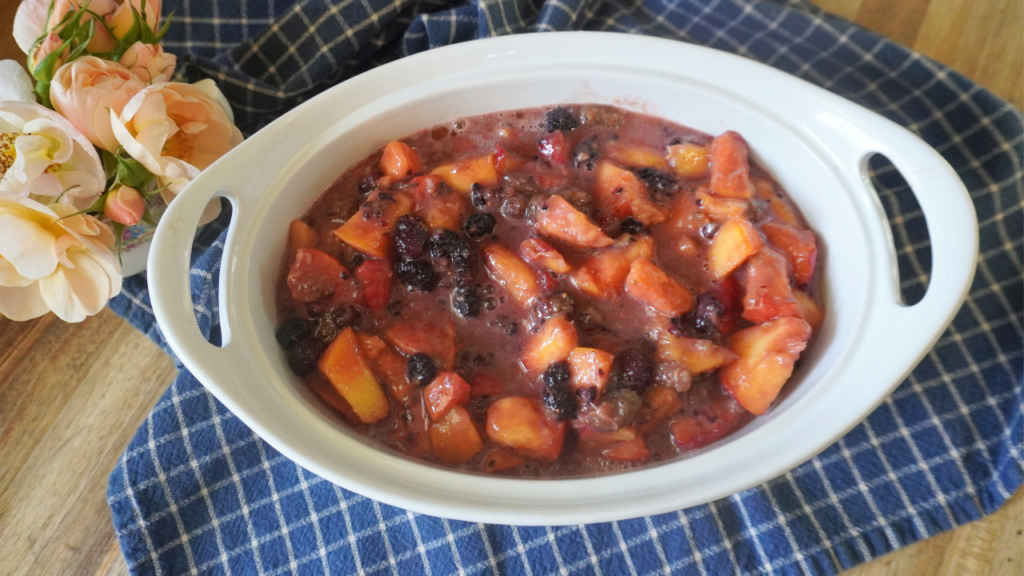 peach mullberry filling in baking dish with flowers on side