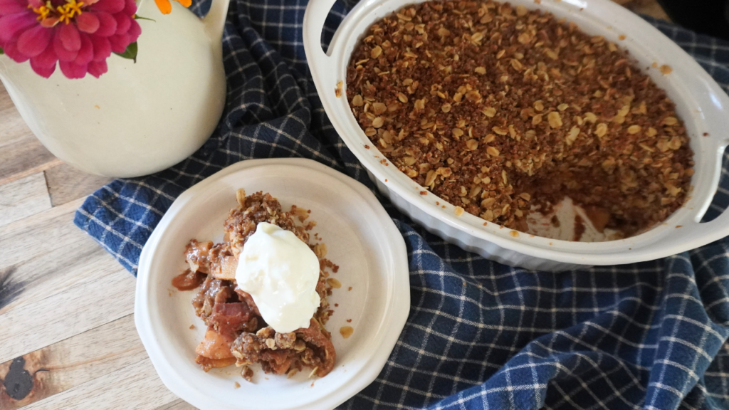 crisp in baking dish with some on plate with cream on top