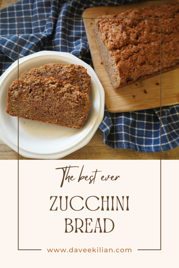 zucchini bread pin with two slices on plate and rest of bread on cutting board