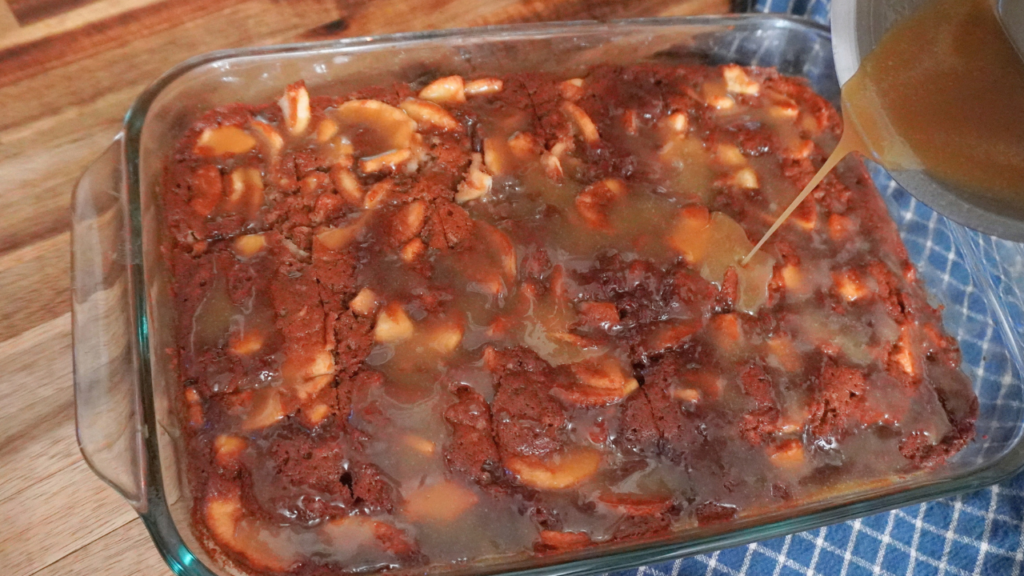 Pouring sauce over baked apple cake